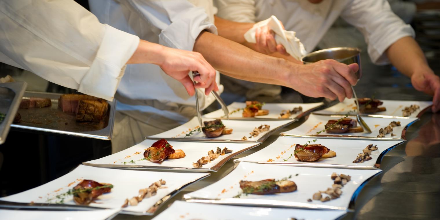 Chefs preparing food on a plate